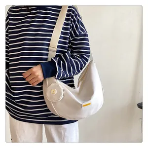 Detail of a beige nylon crescent crossbody bag with mini round pouch and fashion label