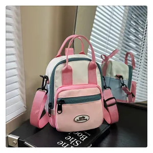 Detail showing tricolor patchwork crossbody bag with durable nylon straps and brand logo