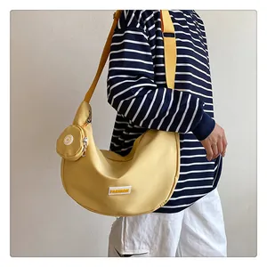 Detail of a bright yellow hobo nylon bag with an adjustable strap and small round coin purse
