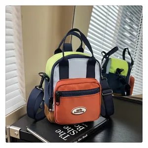 Detail of multi-color nylon mini bag with smooth zippers and neon green accents