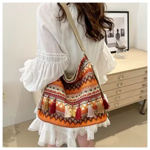 Detail of bohemian shoulder bag with ethnic geometric patterns and colorful fringes