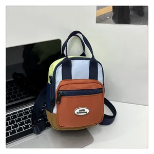 Detail showing the multicolor patchwork fabric mini bag with adjustable strap and front logo