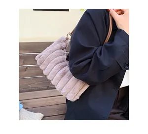 Detail of plush tote bag showing quilted texture and metal ring connection on shoulder strap