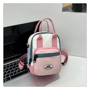Detail of a color-block mini backpack with dual handles and smile fashionbag tag
