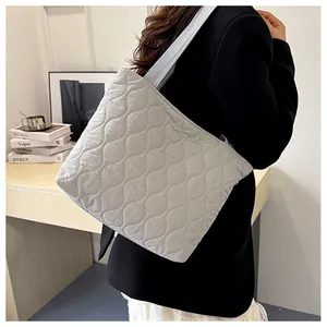 Detail view of wavy quilted light gray tote bag with wide nylon shoulder straps