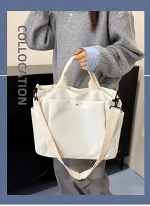 Gros plan d'un sac cabas en toile blanche avec boucle magnétique et bandoulière réglable