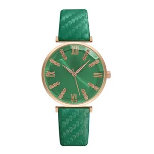 Dettaglio orologio con quadrante verde sfaccettato e cinturino in pelle testurizzata