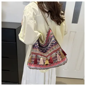 Detail of bohemian woven bag with ethnic geometric patterns and colorful tassels