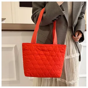 Detail of red quilted space cotton tote bag with unique leaf pattern stitching texture