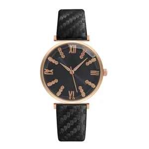 Dettaglio dell'orologio oro rosa con numeri romani e cinturino trama in carbonio