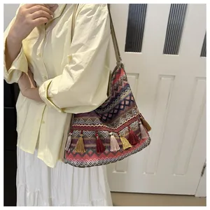 Close-up of ethnic style tote bag featuring colorful woven patterns and tassel fringe details