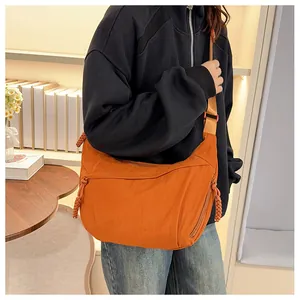 Detail of bright orange nylon crescent bag with adjustable strap and rope zipper pull