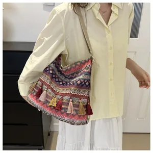Detail of bohemian woven shoulder bag featuring colorful patterns and ethnic tassels