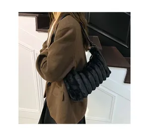Detail of black faux fur tote bag showing striped texture and leather shoulder strap