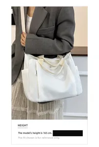 Grand sac fourre-tout en toile blanche avec bandoulière sur un modèle de 165 cm