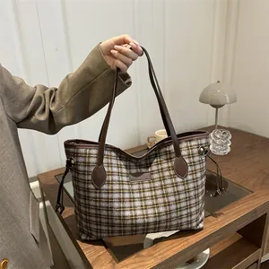 Retro plaid wool tote bag with brown leather handles shown in a cozy indoor setting
