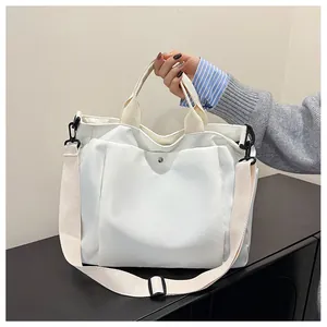 Détails du sac cabas en toile blanche avec bandoulière réglable et poche à bouton