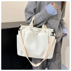 Détail du sac cabas en toile blanche avec fermoir magnétique et large bandoulière