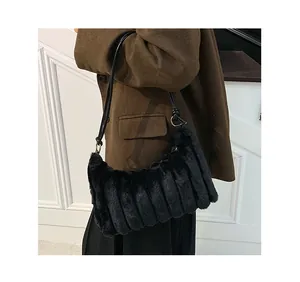 Detail of black faux fur tote bag showing textured plush fabric and leather shoulder strap