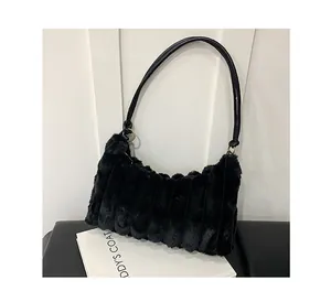 Detail of black plush tote bag featuring vertical ribbed texture and slim leather straps