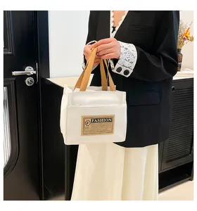 Détail d'un sac cabas en toile crème avec poignées kaki et étiquette de mode stylée