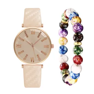 Dettaglio dell'orologio in pelle rosa con quadrante romano e bracciale di perline colorate
