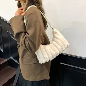 Chic white faux fur tote bag with gold hardware shown on model in a minimalist setting