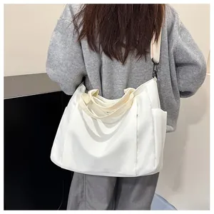 Détails de la toile blanche du sac cabas avec poches latérales et anses tissées