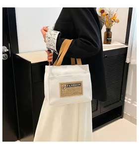 Sac cabas minimaliste en toile blanche avec poignées brunes dans un décor moderne