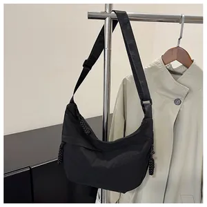Detail of black nylon hobo bag with adjustable strap and braided zipper puller