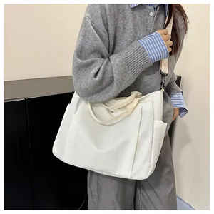 Détail du grand sac cabas en toile blanche avec poches latérales et bandoulière amovible