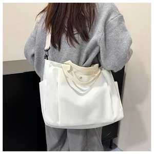 Vue arrière du grand sac cabas blanc en toile avec bandoulière noire sur un mannequin