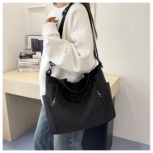 Détail du grand sac cabas noir en toile avec fermetures éclair argentées et large bandoulière