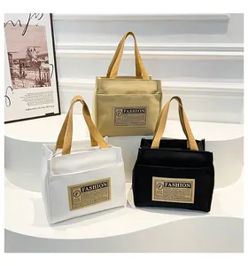 Gros plan de trois sacs en toile beige, blanc et noir avec des étiquettes de mode vintage