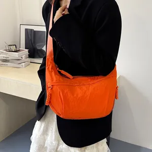 Bright orange nylon crescent crossbody bag with large capacity and stylish knot zipper