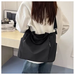 Détails d'un sac cabas noir polyvalent en toile avec poches et bandoulière réglable