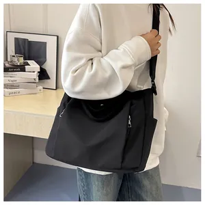 Gros plan du grand sac fourre-tout noir en nylon avec poche latérale zippée pratique