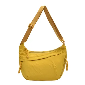 Lightweight bright yellow nylon crescent crossbody bag with adjustable strap and zip pockets