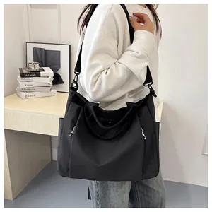 Détail du grand sac cabas noir en nylon avec deux poches avant et bandoulière réglable