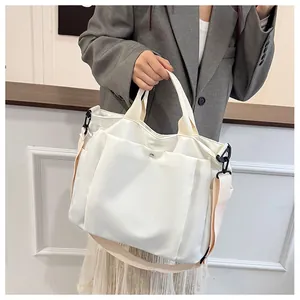 Détails du sac cabas en toile blanche avec poches latérales et bandoulière amovible réglable