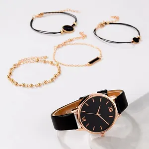 Detail of rose gold watch with black dial and four minimalist matching bracelets