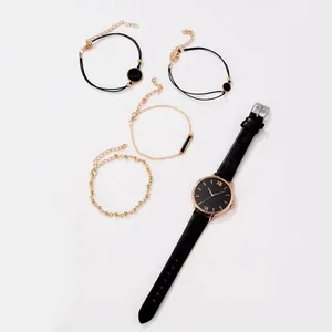 Detailed flat lay of black quartz watch set with four assorted gold and black bracelets
