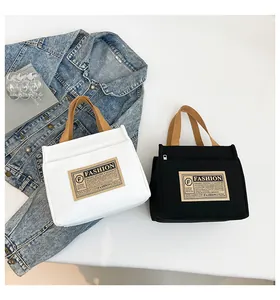 Détail de sacs fourre-tout en toile blanche et noire avec étiquettes de mode vintage