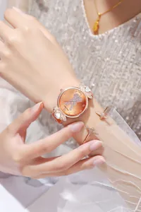 Dettaglio orologio con coniglio in oro rosa, quadrante arancione e anse con cuore di cristallo
