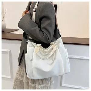 Détail du grand sac cabas blanc en toile avec poche latérale et bandoulière réglable