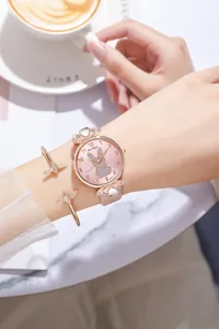 Dettaglio orologio donna con coniglio rosa e bracciale uccello oro rosa al polso