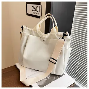 Vue détaillée du grand sac cabas en toile avec bandoulière réglable et poche avant