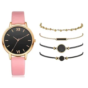 Pink PU leather watch set with four matching gold-toned and black bracelets on white background
