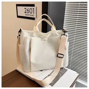 Détail d'un sac cabas en toile crème avec poche zippée latérale et bandoulière