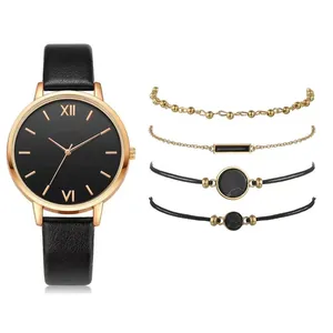 Detail of rose gold quartz watch with black leather strap and four minimalist bracelets